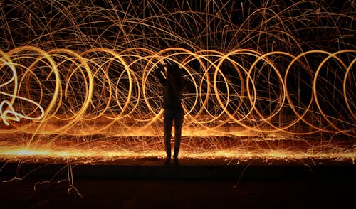 Silhouette of a Person Standing Near Spiral Lights 