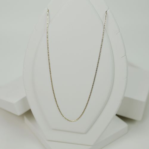 Free Elegant gold chain necklace displayed on a white stand with a minimalist backdrop. Stock Photo