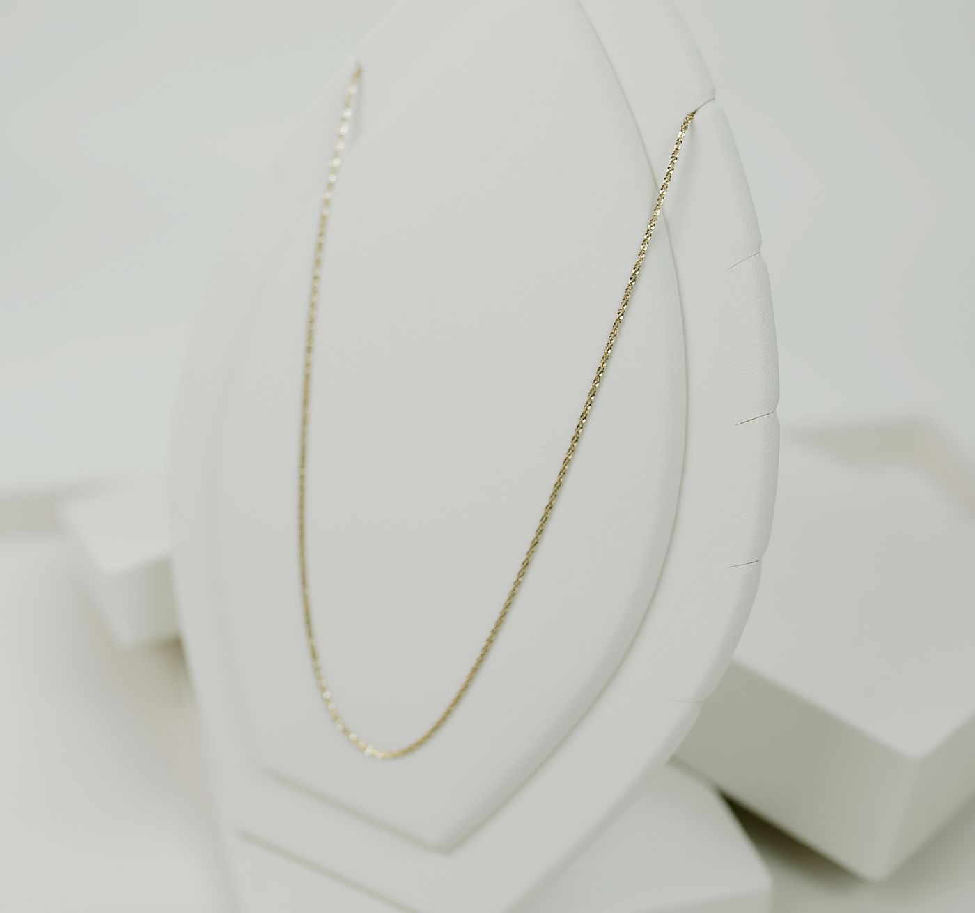 Collier fin en or sur présentoir