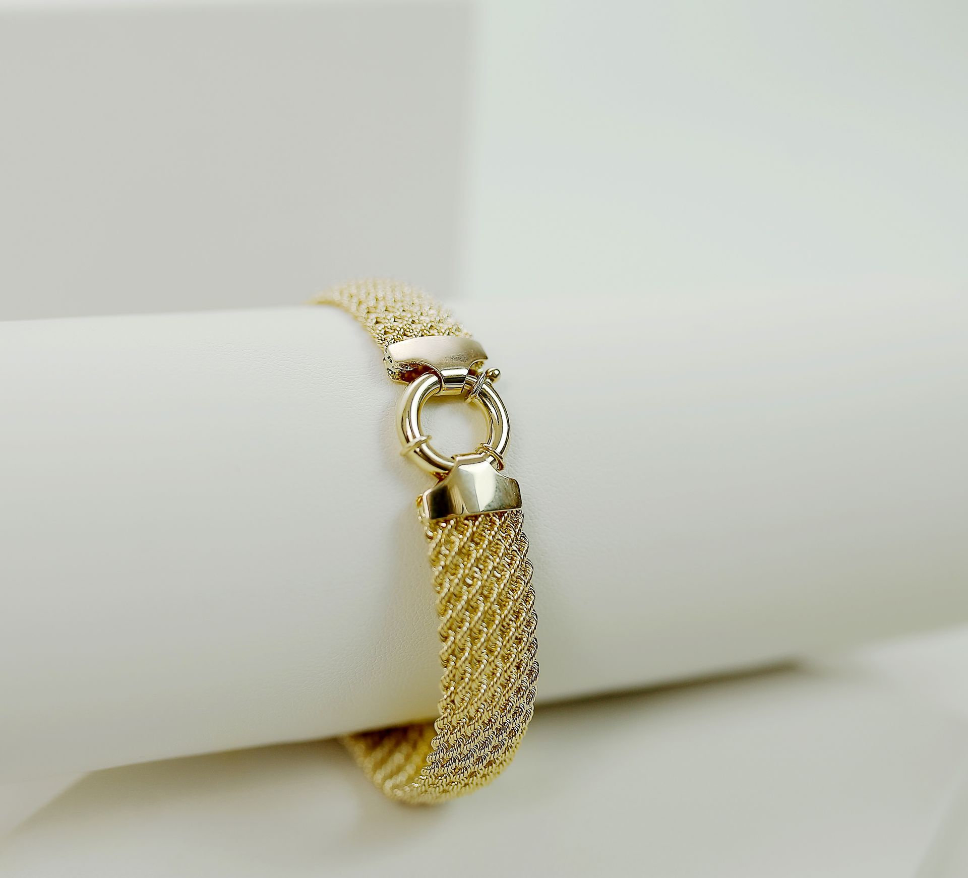 Close-up of a luxurious gold bracelet showcasing its intricate design, perfect for fashion and jewelry enthusiasts.