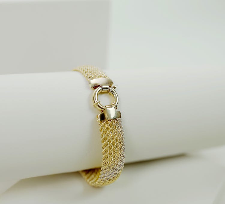 A Gold On A White Bracelet Holder