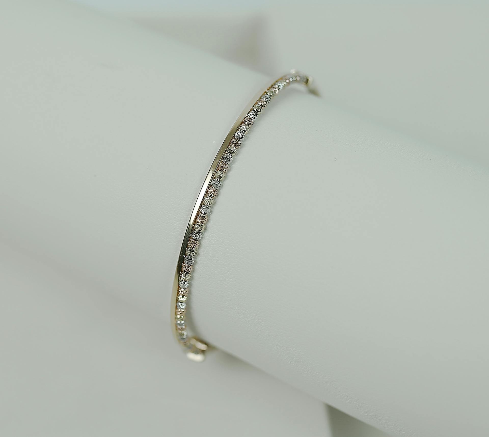 A luxurious white gold bracelet adorned with diamonds on a minimalist background.