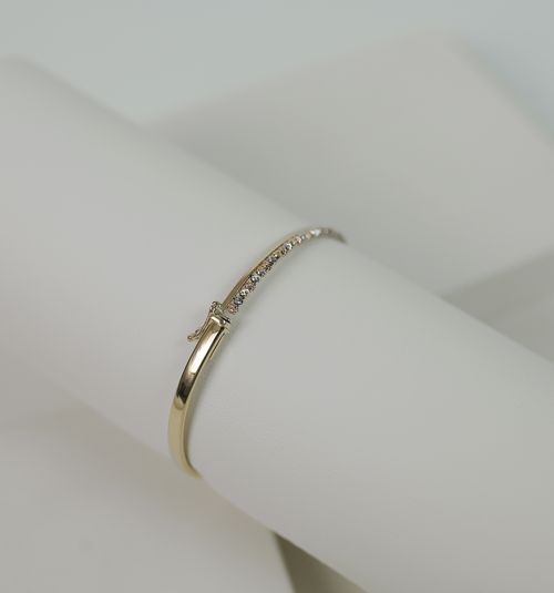 Free Close-up of a luxurious gold bracelet with diamonds on a white background, showcasing elegance and style. Stock Photo