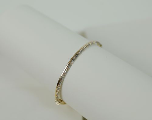 Free Close-up of a luxurious gold bracelet adorned with diamonds on a white background. Stock Photo