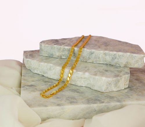 Free Close-up of a gold necklace elegantly displayed on marble stones, perfect for showcasing luxury jewelry. Stock Photo