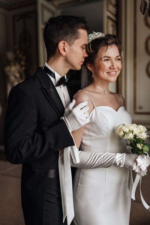 Free Charming couple in wedding attire, sharing a tender moment indoors. Stock Photo