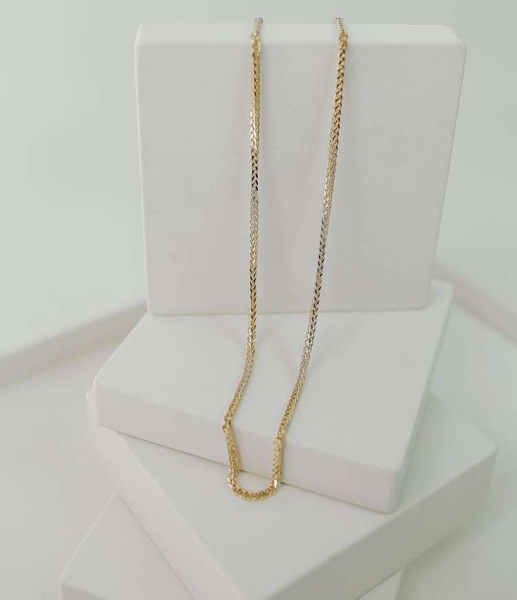 Gold Necklace On White Platform