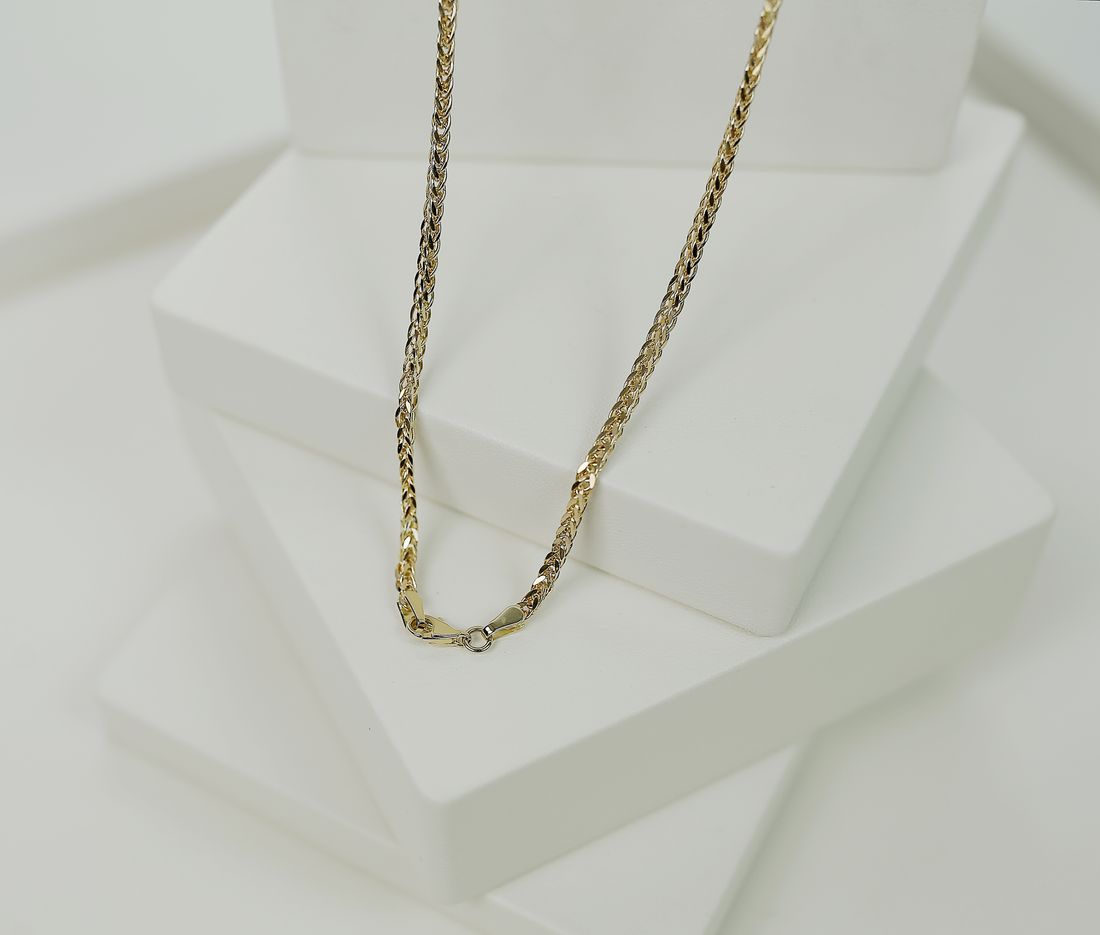 Sculptural two-tone necklace arranged on white display platforms