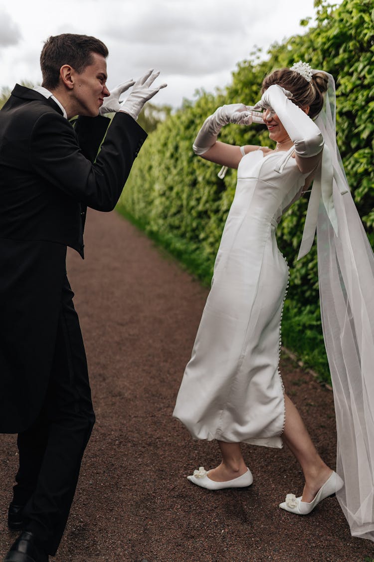 A Couple In Wedding Attires Being Goofy