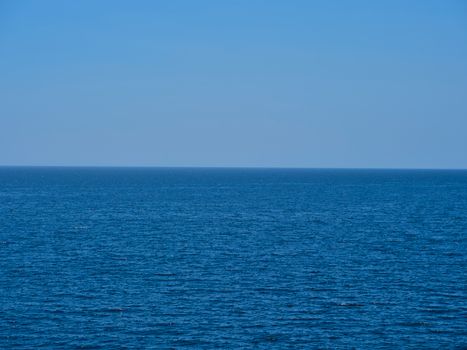 A tranquil seascape with endless blue ocean meeting the clear sky, capturing nature's calmness.