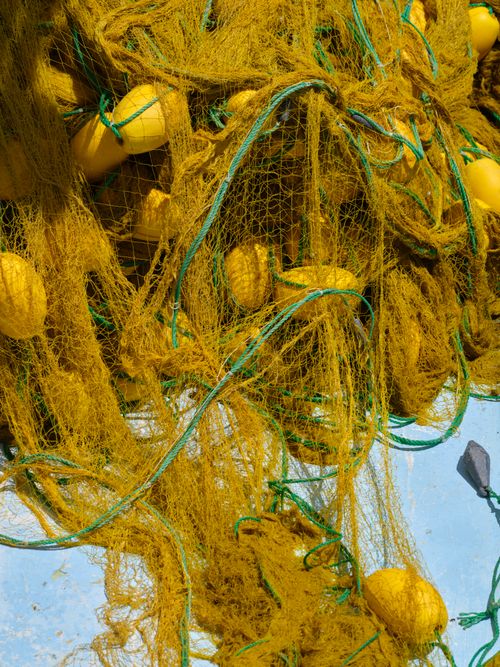 Free Vibrant yellow fishing nets and floats against a bright sunny backdrop. Stock Photo