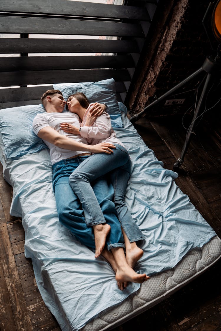 A Man And Woman Lying On Bed