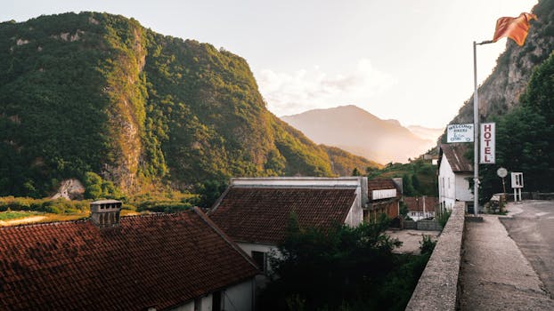 Charming Montenegro countryside with mountain backdrop and hotel at sunrise.