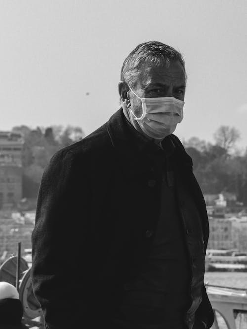 Grayscale Photo of a Man Wearing a Face Mask
