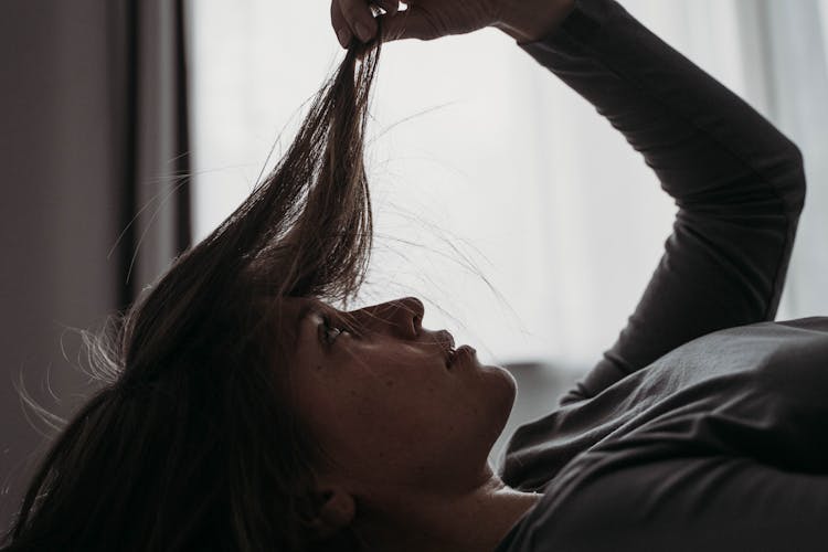 Close-up Photo Of Woman Looking On Her Hair 