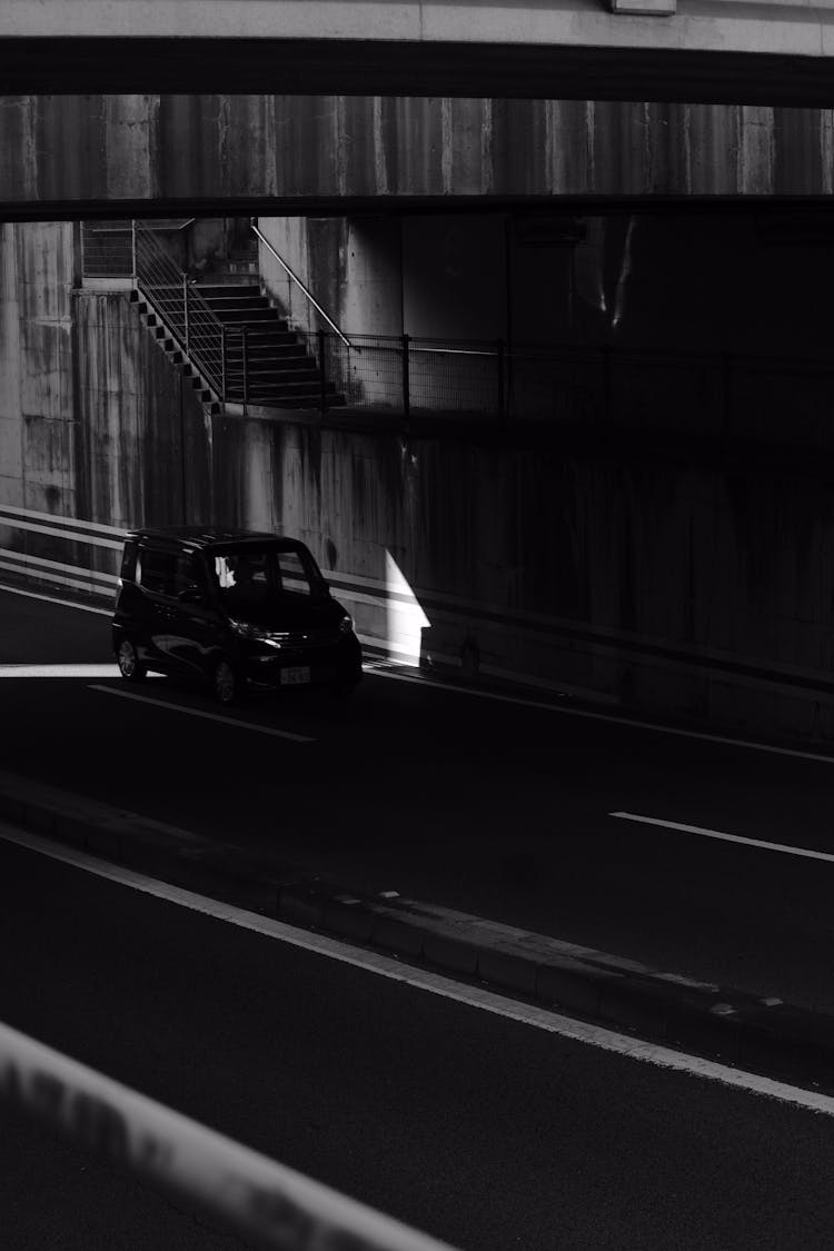 A Car Moving On The Road Under The Bridge