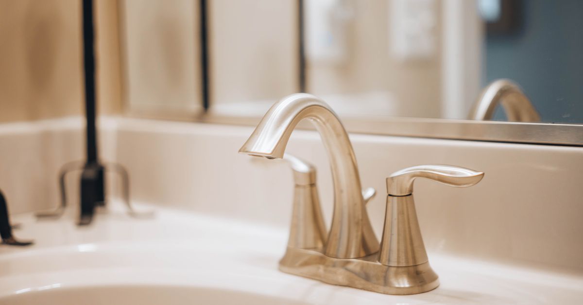 Close-up of a sleek modern bathroom faucet reflecting elegance and luxury.