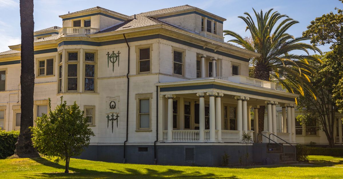 Elegant colonial mansion with classic columns in a sunny outdoor setting.