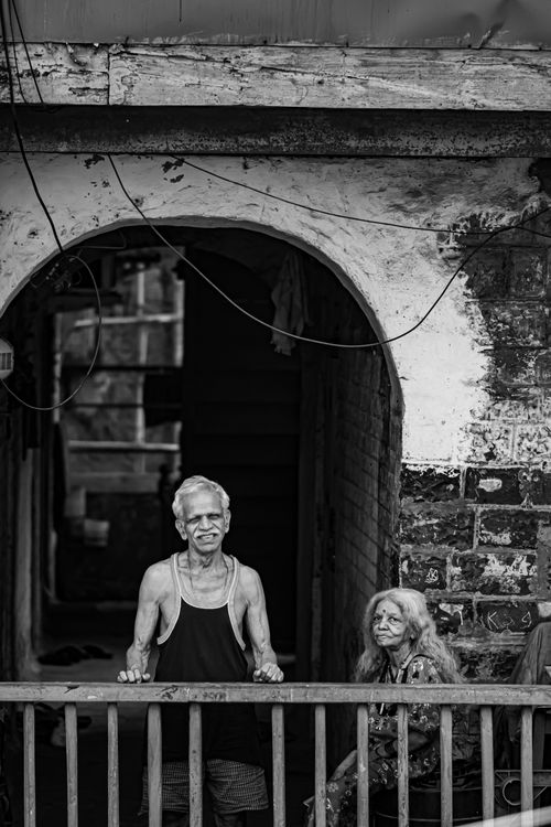 Free Elderly couple standing in an arched gateway, Mumbai, India. Stock Photo