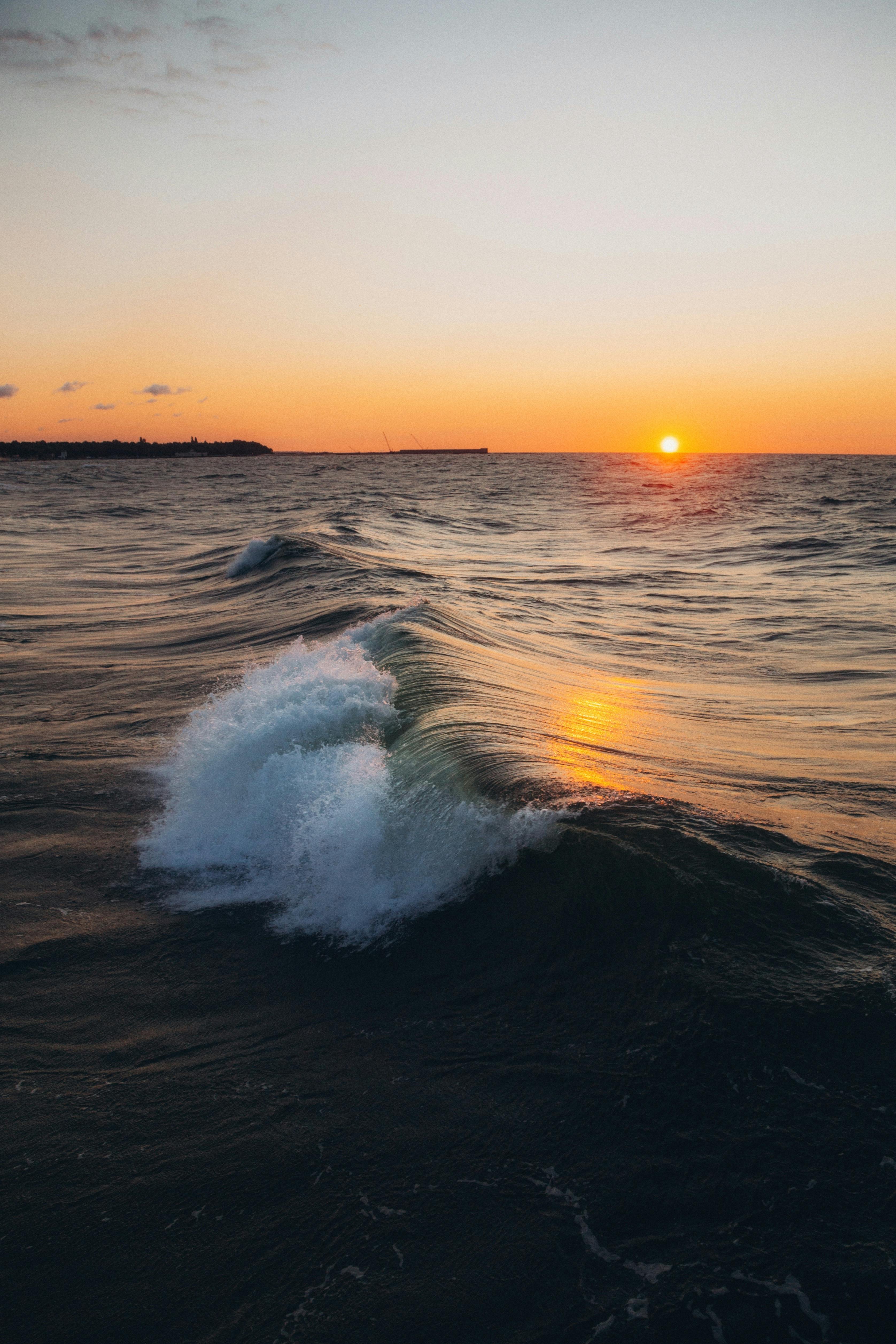 A breathtaking view of ocean waves at sunrise with vibrant colors illuminating the seascape.