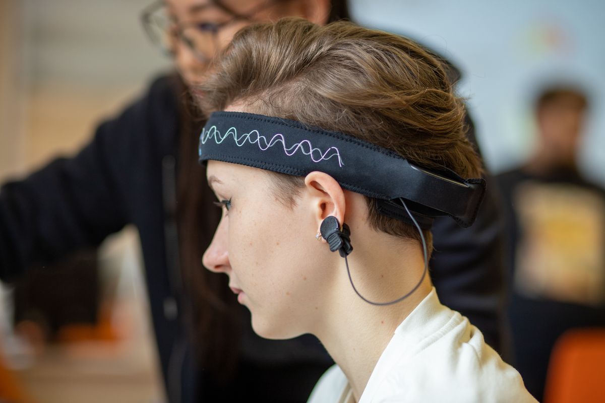 A person wearing an EEG-style headband seated at a computer screen during a session.