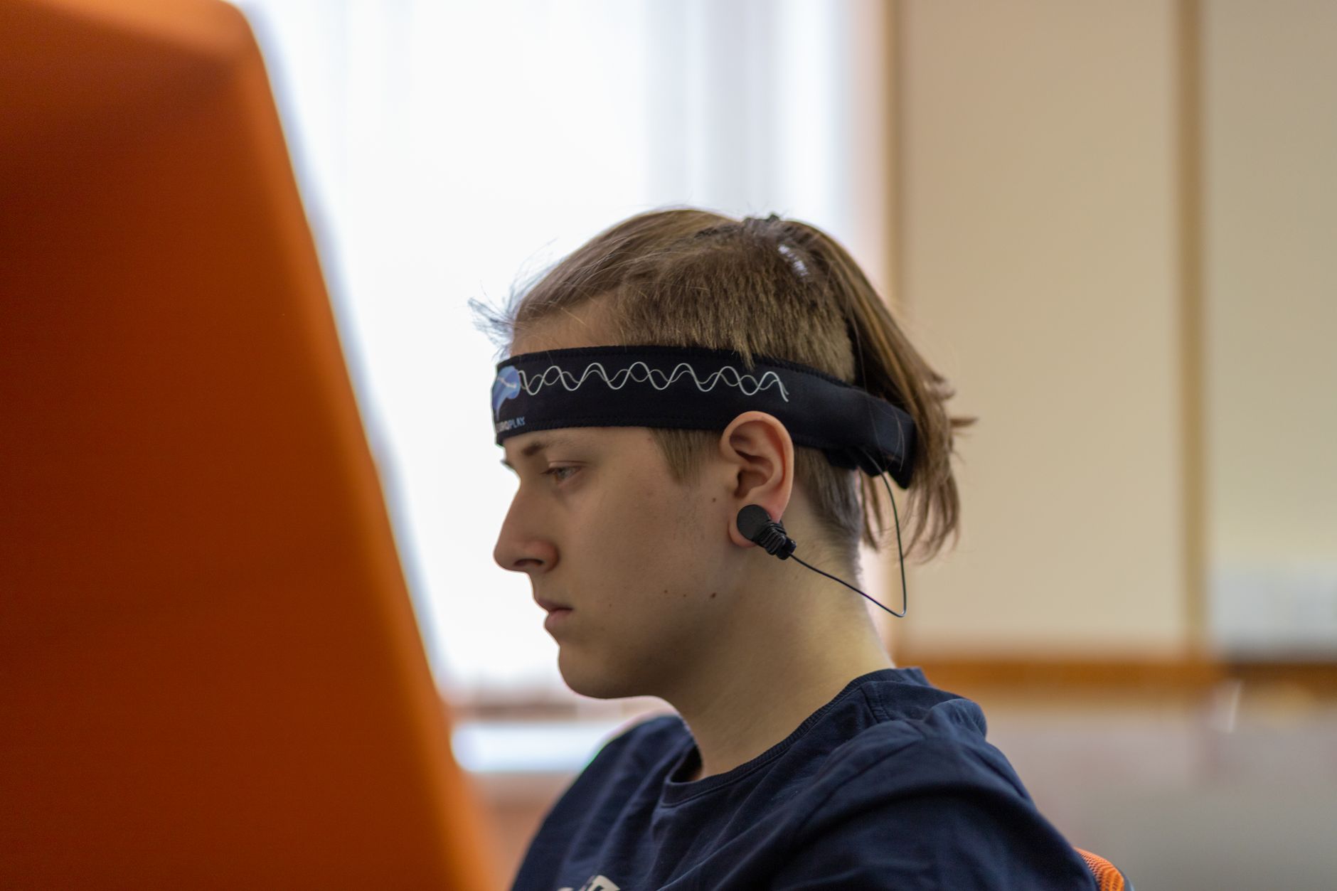 A user wearing a sleek headband designed for brain activity tracking during a work session.