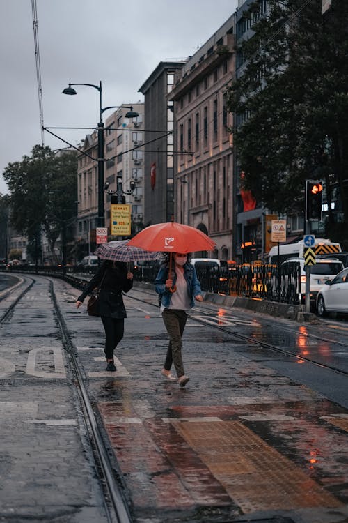 Free Two People Walking on the Street while Holding Their Umbrella Stock Photo