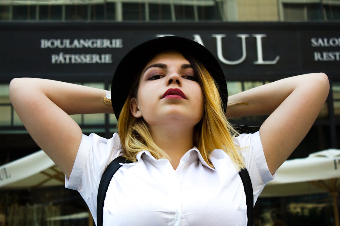 無料 黒のfedora帽子をかぶった白いポロシャツの女性 写真素材