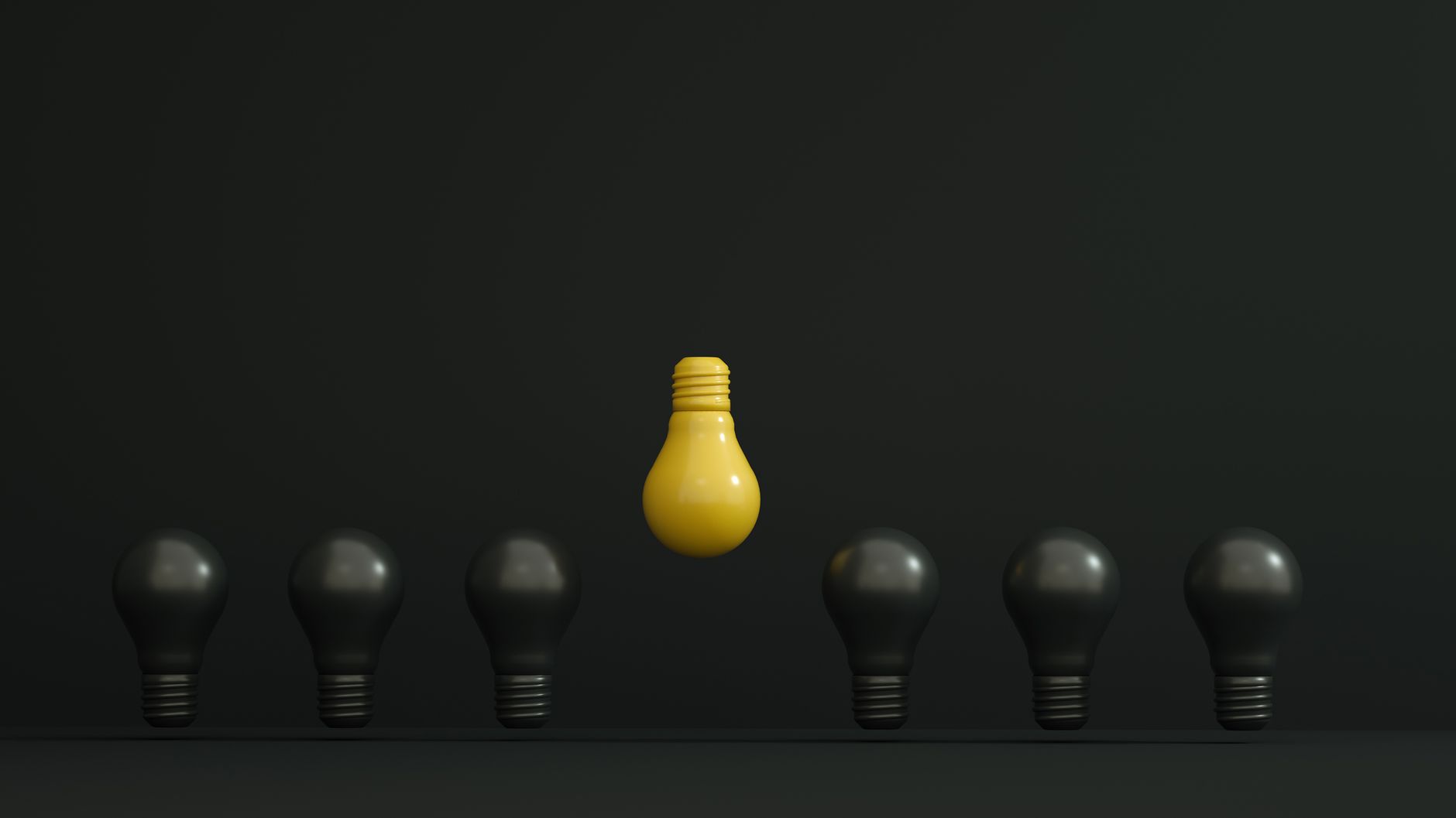 A single yellow light bulb highlighted among dark ones symbolizing creativity and innovation.