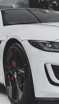 Close-up of a modern white car's front wheel, showcasing sleek design and black tire.