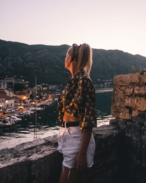 Free Caucasian woman in stylish outfit enjoying the sunset view over Kotor Bay, Montenegro Stock Photo