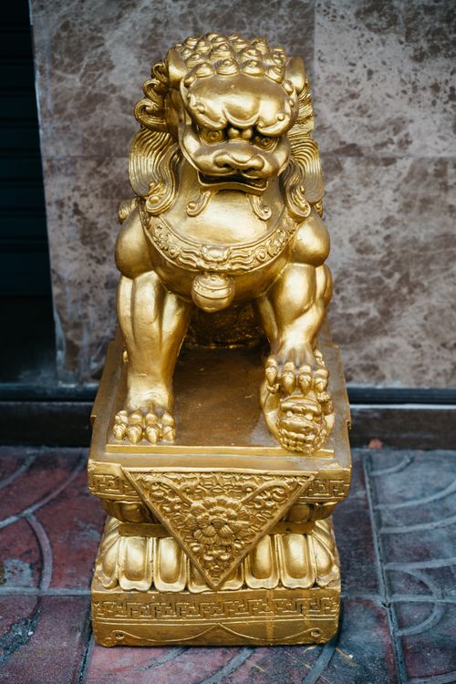 Free Elegant close-up of a golden oriental lion statue, showcasing intricate carvings. Stock Photo