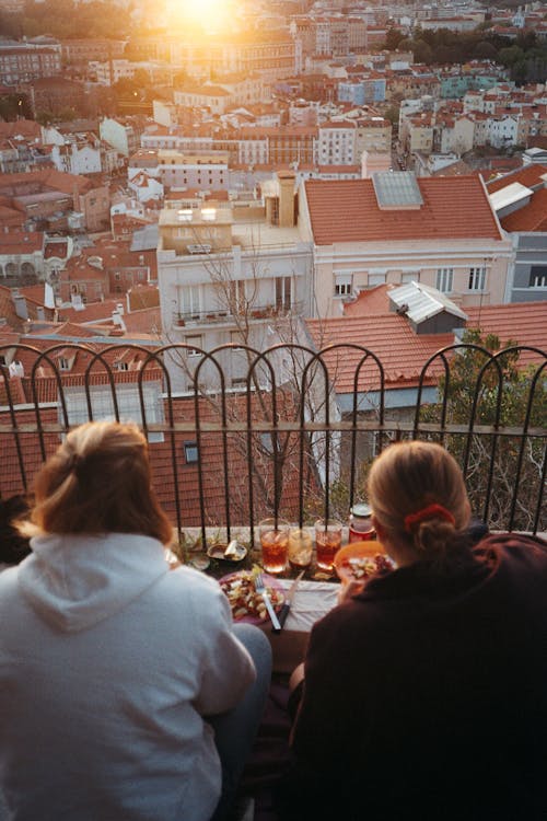Backview of Women eating while overlooking a Town 