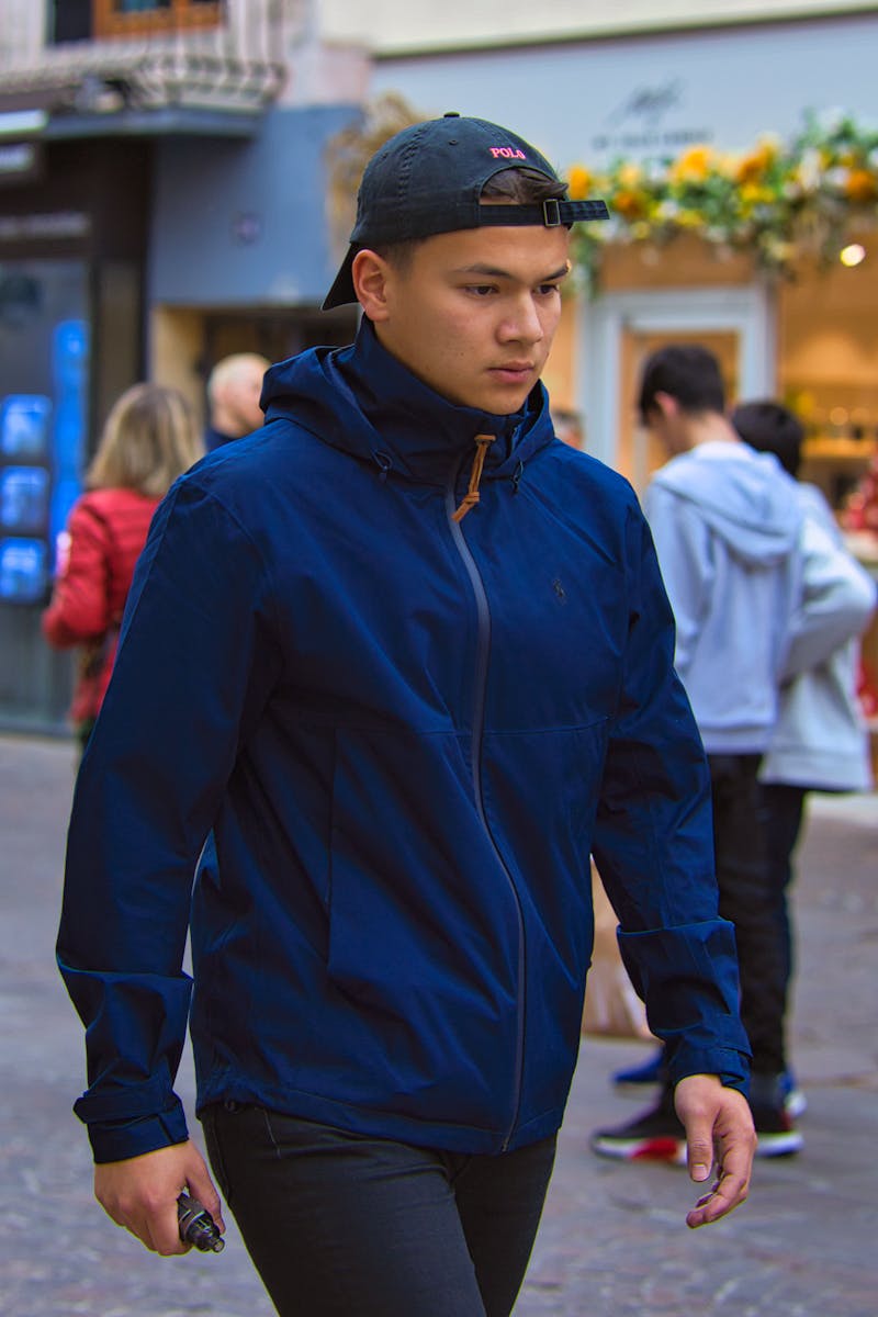 Man in Blue Zip Up Jacket Standing on Street