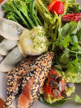 Tasty salad with sesame salmon, dumplings, and fresh vegetables, Berlin, Germany.