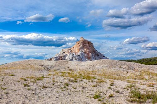 Free Scenic view of a rocky geothermal feature under a blue sky in Yellowstone National Park. Stock Photo