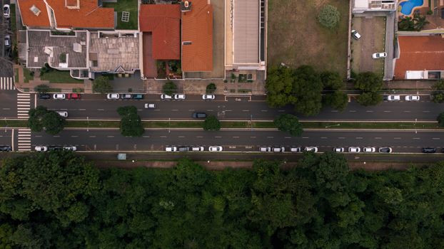 Aerial view of suburban street with traffic and lush greenery in Paraná, Brazil.