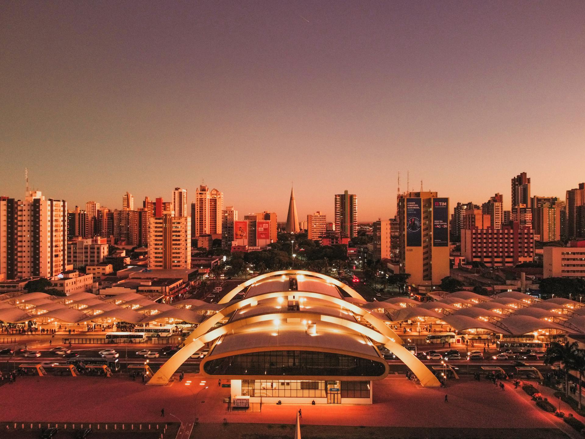 Stunning aerial view of Maringá, Brazil's skyline at dusk, highlighting the intermodal terminal and cityscape.