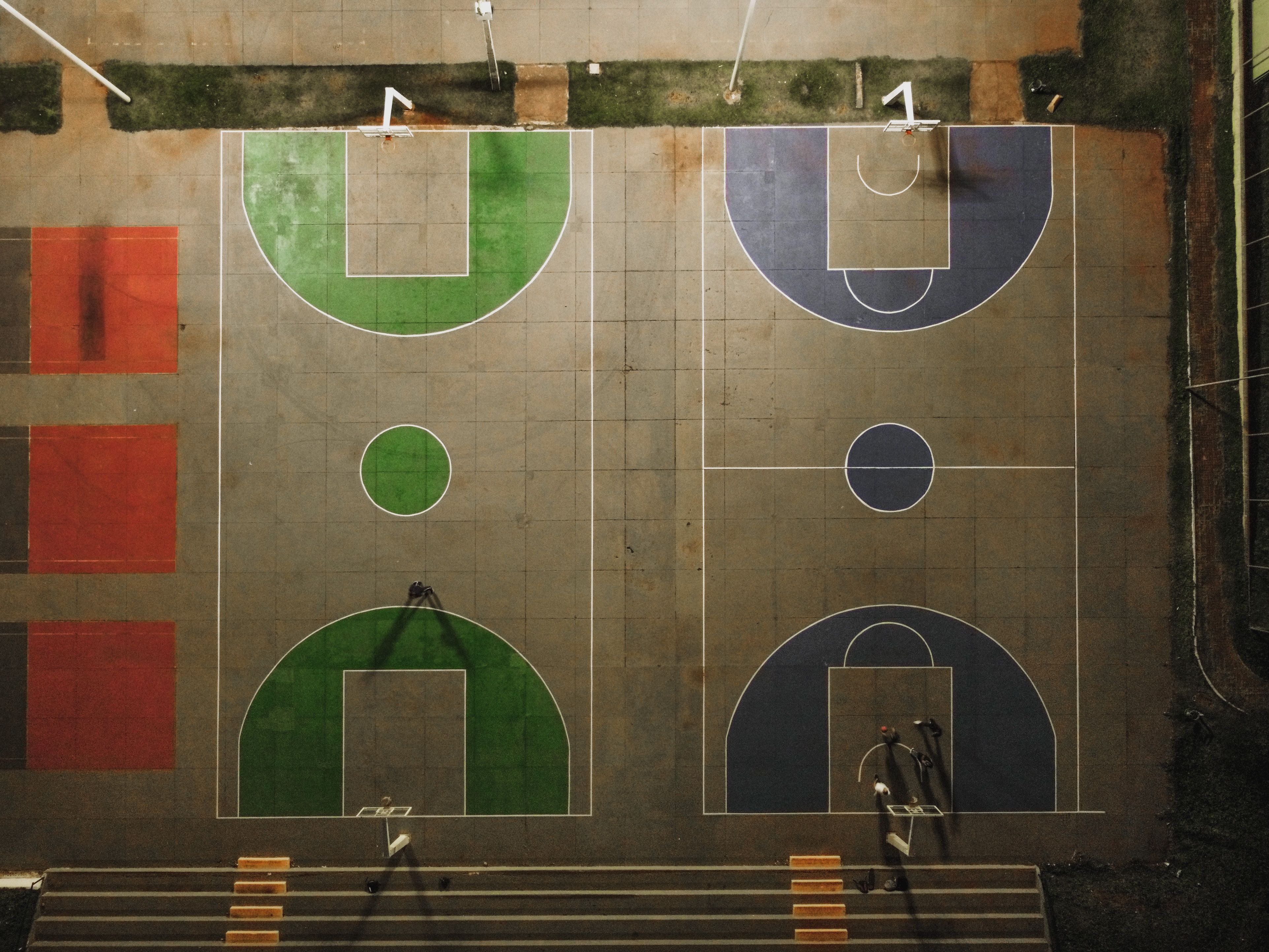 Top-down view of vibrant basketball courts at night in Brazil, showing detailed court markings.