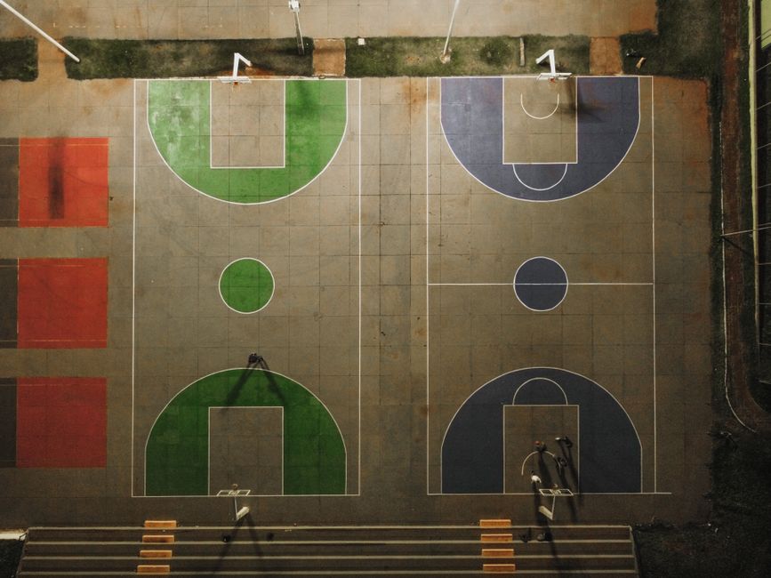 Top-down view of vibrant basketball courts at night in Brazil, showing detailed court markings.