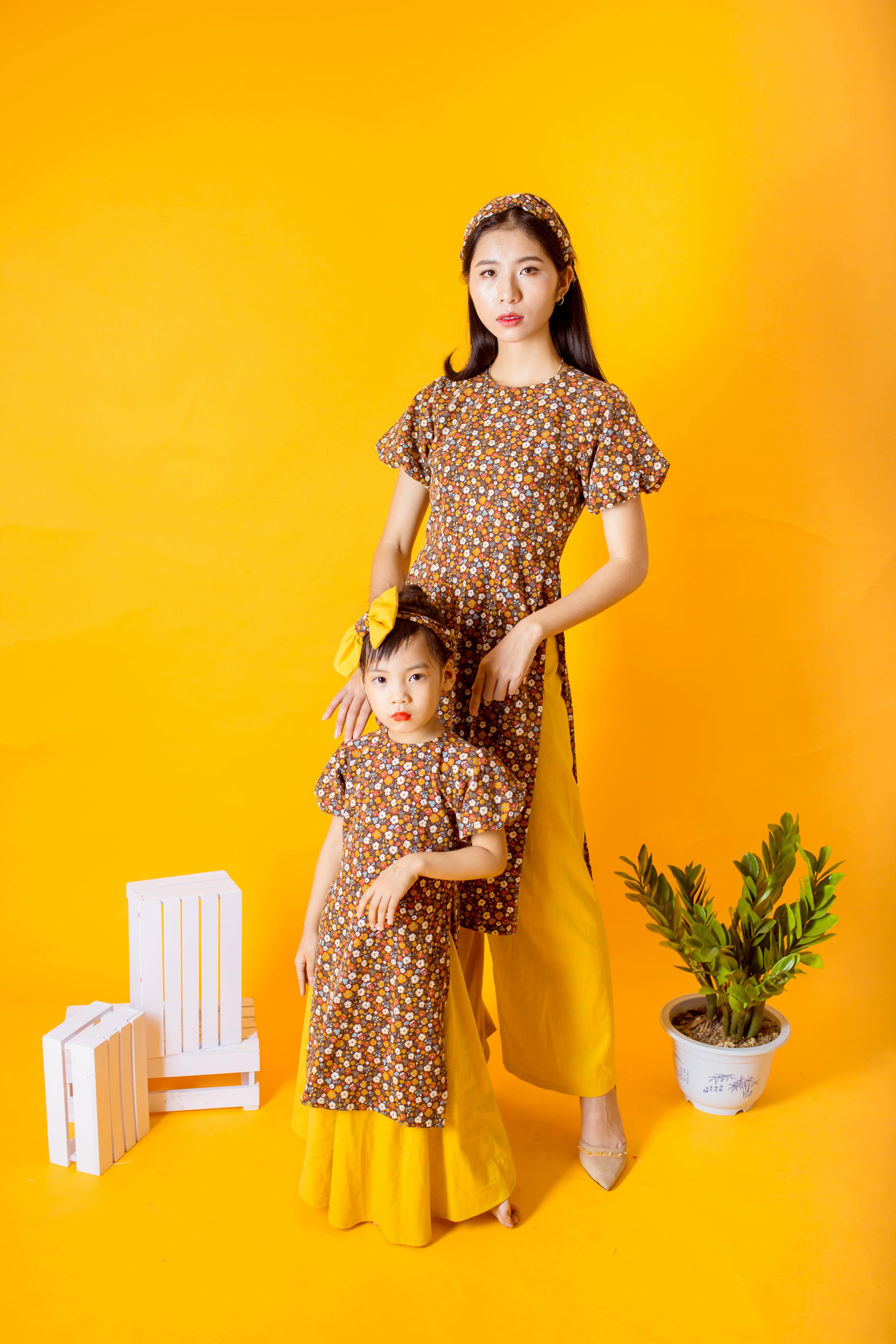 woman and a girl wearing matching floral dress