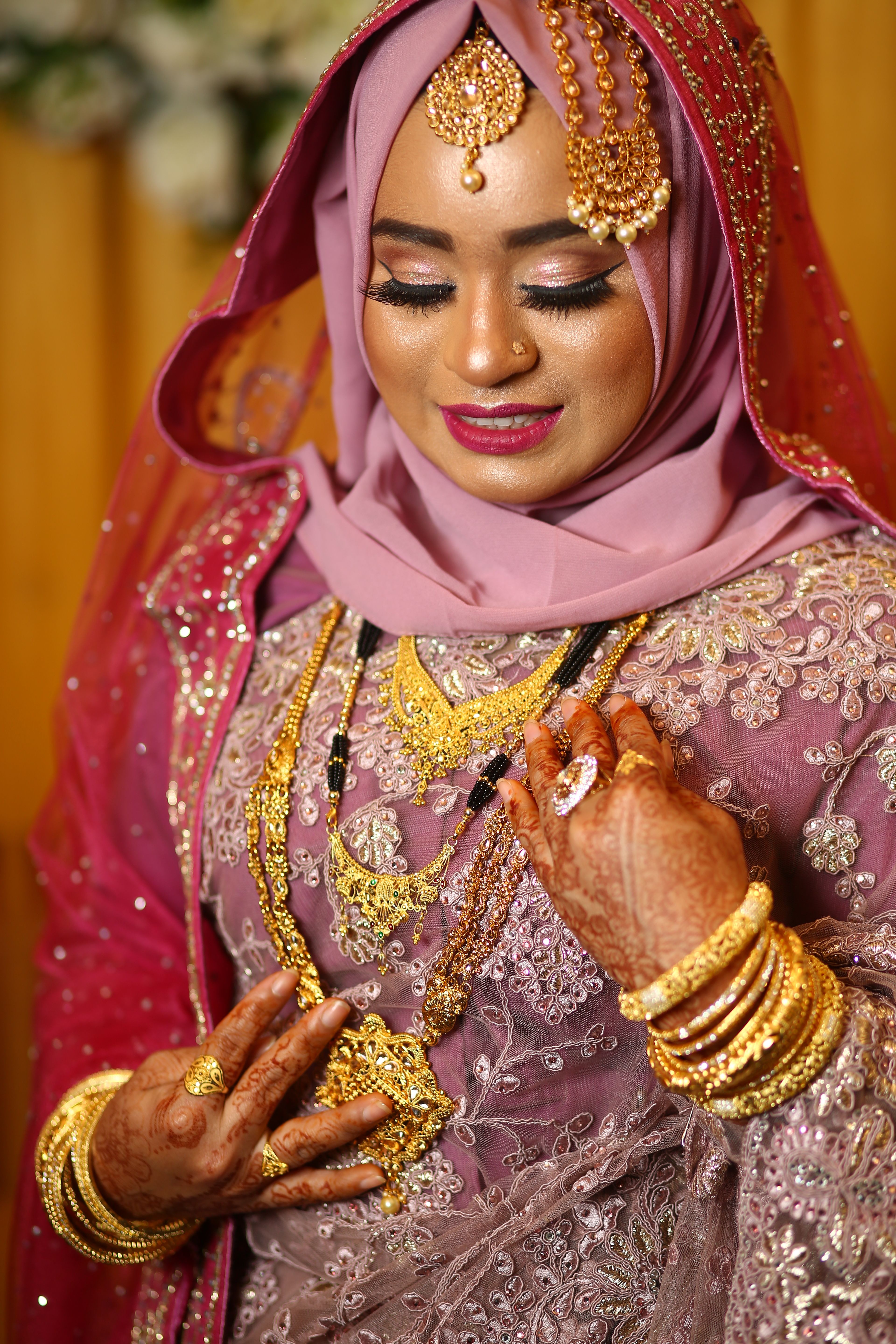 A beautiful bride adorned in gold jewelry and traditional attire highlights cultural elegance.