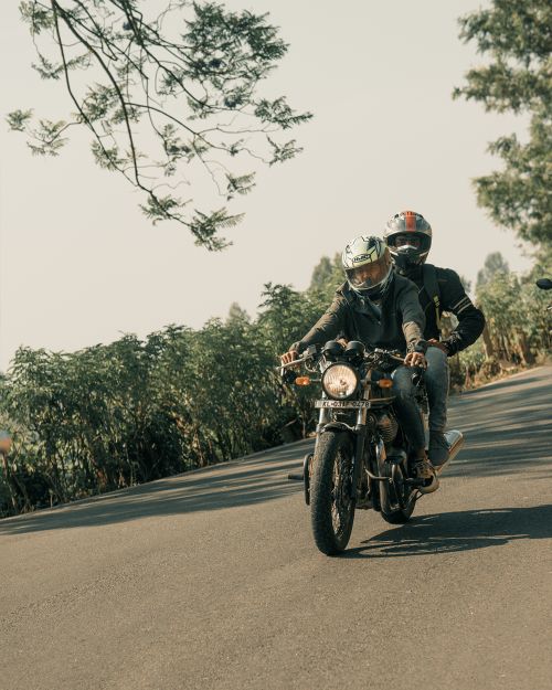 Free Two men in helmets safely enjoying a ride on a scenic road. Stock Photo