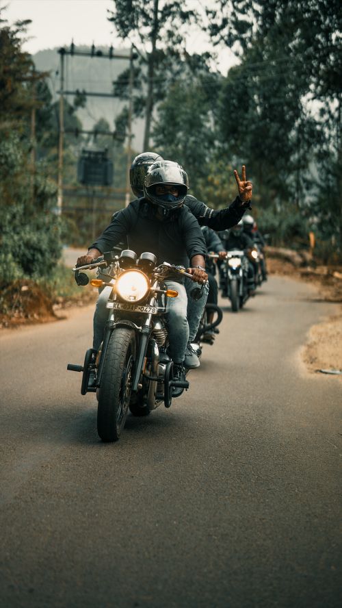 Free A group of bikers wearing helmets rides motorcycles on a scenic road, enjoying an adventurous trip. Stock Photo