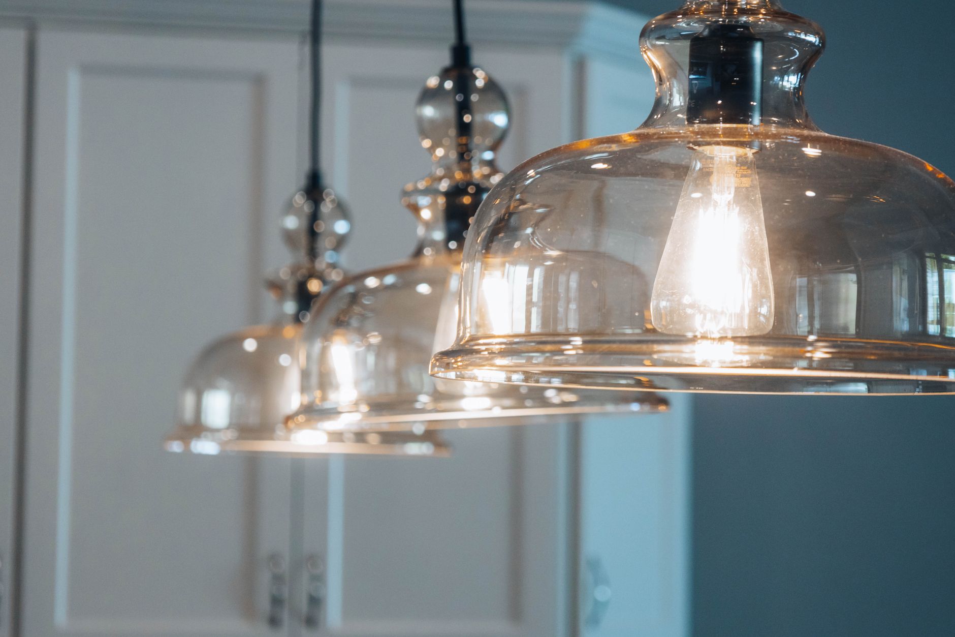 Close-up of stylish glass pendant lamps illuminating a modern indoor space.