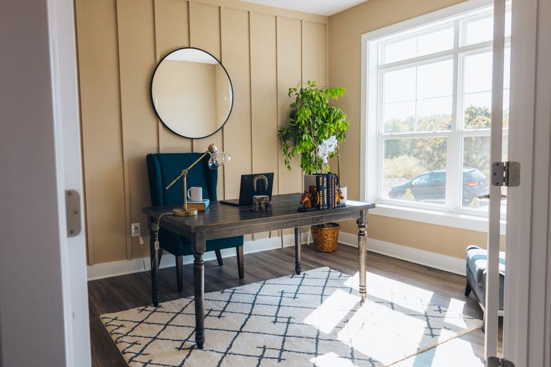 small desk positioned facing a window with natural light