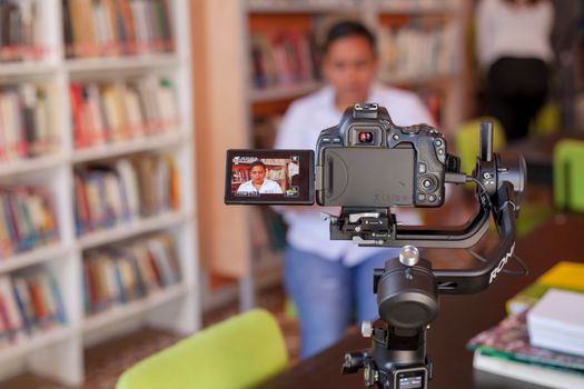 Professional video recording setup in a vibrant library environment.