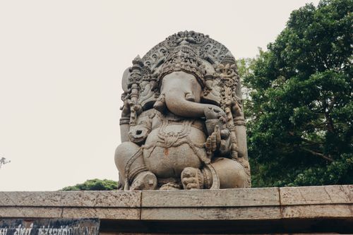 Free Elegant Ganesha stone statue amidst lush green trees, showcasing rich cultural heritage. Stock Photo