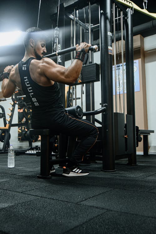 Free A Muscular Man using a Lat Pull-Down Machine in a Gym Stock Photo
