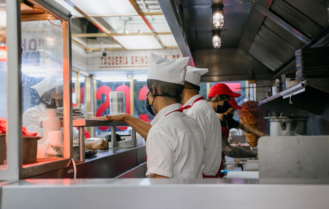 Restaurant kitchen staff preparing meals in a busy commercial kitchen